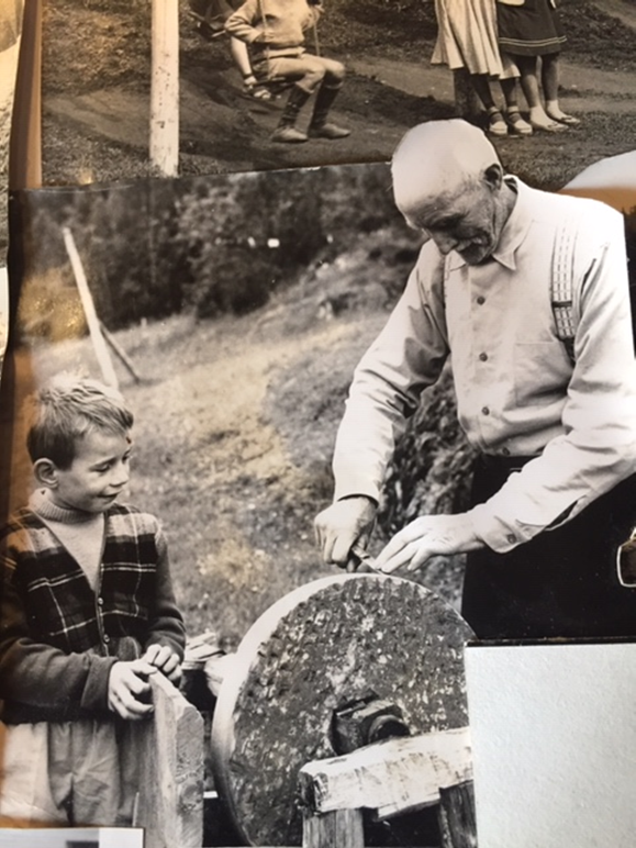 Johan sliper kniv på slipestein. Guttene fulgte ofte Johan i hans daglige gjøremål. «Bestefar» er ved flere anledninger omtalt som en snill mann.